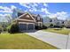 Beautiful home exterior with a two-car garage, lush green lawn, and tasteful landscaping in a serene setting at 3950 Almandine Way, Cumming, GA 30040