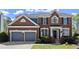Lovely two-story brick home featuring an attached two-car garage and manicured front yard at 3950 Almandine Way, Cumming, GA 30040