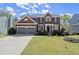 Traditional two-story brick home with a manicured lawn, a two-car garage, and charming front-yard garden at 3950 Almandine Way, Cumming, GA 30040
