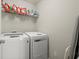 Laundry room with modern washer and dryer and storage shelves at 3950 Almandine Way, Cumming, GA 30040
