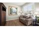 Cozy living room with hardwood floors, a comfortable sofa, and natural light streaming through the window at 3950 Almandine Way, Cumming, GA 30040
