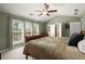 Primary bedroom with a ceiling fan, vaulted ceiling, and three windows at 3950 Almandine Way, Cumming, GA 30040