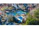 Aerial view of community with a pool, tennis court, mature trees, and a basketball court at 4620 Westgate Dr, Cumming, GA 30040