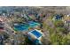 Aerial view of community with a pool, tennis court, mature trees, and a basketball court at 4620 Westgate Dr, Cumming, GA 30040