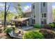 Backyard featuring a covered patio with dining and seating, a stone fire pit, lush landscaping, and a well-maintained lawn at 4620 Westgate Dr, Cumming, GA 30040