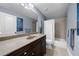Well-lit bathroom featuring a shower-tub combination, vanity with dark wood cabinets and neutral countertop, and blue wall color at 4620 Westgate Dr, Cumming, GA 30040