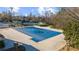 Large community pool covered for the off-season, surrounded by lush landscaping and tennis courts at 4620 Westgate Dr, Cumming, GA 30040