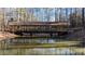 Tranquil scene of a covered bridge reflecting in a serene pond surrounded by trees at 4620 Westgate Dr, Cumming, GA 30040