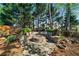 Picturesque backyard firepit area with stone seating and surrounding landscaping at 4620 Westgate Dr, Cumming, GA 30040