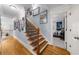 Hallway featuring beautiful wood floors, a decorative staircase, and a gallery wall with framed photos at 4620 Westgate Dr, Cumming, GA 30040
