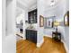 Hallway featuring wooden floors with a bar area and decorative mirror at 4620 Westgate Dr, Cumming, GA 30040