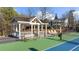 Well-maintained tennis court with a shaded gazebo, offering a relaxing spot for players at 4620 Westgate Dr, Cumming, GA 30040