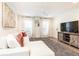 Open living room with a tv, modern sofa, and bright natural light at 1101 Collier Nw Rd # U2, Atlanta, GA 30318