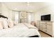 Spacious main bedroom showcasing neutral tones, ceiling fan, and an arrangement of dressers and windows at 1101 Collier Nw Rd # U2, Atlanta, GA 30318