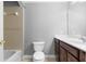 Bathroom featuring a vanity with dark wood cabinetry, a toilet, and a tub with a tiled surround at 1350 Blackwell Rd, Marietta, GA 30066