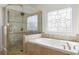 Elegant bathroom featuring a soaking tub, glass shower, and decorative window at 1350 Blackwell Rd, Marietta, GA 30066