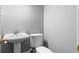 Simple powder room with a pedestal sink and toilet in a neutral color palette at 1350 Blackwell Rd, Marietta, GA 30066