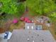 A high angle shot of the backyard with a stone fire pit, sitting area, landscaped with mature flowering shrubs and fresh mulch at 1606 Nuthatch Ct, Marietta, GA 30062