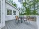 Outdoor dining area with a table and chairs on a wood deck overlooking the lush, green backyard at 1606 Nuthatch Ct, Marietta, GA 30062
