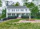 Two-story home featuring a large front yard with mature trees, a porch, and a second story balcony at 1606 Nuthatch Ct, Marietta, GA 30062