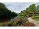 Picturesque lake view with a pergola, landscaped pathway, and an American flag at 1606 Nuthatch Ct, Marietta, GA 30062