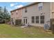 Exterior view of the home's backyard with a small patio, green grass and an AC unit at 587 Jody Pl, Lilburn, GA 30047
