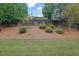 Fenced backyard with plush lawn, trimmed bushes, and mature trees at 587 Jody Pl, Lilburn, GA 30047