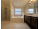 Bathroom featuring a soaking tub, glass enclosed shower, and a double vanity at 2692 Briaroak Dr, Duluth, GA 30096