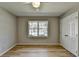 A bright bedroom features wood-look floors, a ceiling fan, and a large window for natural light at 3081 Frankie Ln, Duluth, GA 30096