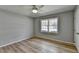 A bright bedroom features wood-look floors, a ceiling fan, and a large window for natural light at 3081 Frankie Ln, Duluth, GA 30096