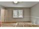 A bright bedroom features wood-look floors, a ceiling fan, and a large window for natural light at 3081 Frankie Ln, Duluth, GA 30096