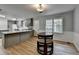 Kitchen features a modern island with white countertop space, stainless appliances and dark wood table at 3081 Frankie Ln, Duluth, GA 30096