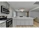 Spacious kitchen island featuring gray cabinets, stainless steel appliances, and hardwood floors at 3081 Frankie Ln, Duluth, GA 30096