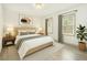 Staged bedroom features a comfortable bed, side tables, lamps and neutral decor at 609 Spring St, Atlanta, GA 30354