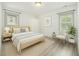 Staged bedroom with wood-look flooring and abundant natural light coming through two windows at 609 Spring St, Atlanta, GA 30354