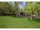 Expansive backyard with lush green grass, mature trees, and a wooden fence providing privacy at 6332 Fairoaks Pl, Douglasville, GA 30135