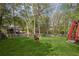 Large backyard with lush green grass, trees, and a privacy fence at 6332 Fairoaks Pl, Douglasville, GA 30135