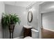 Basement bathroom featuring tile flooring, decorative mirror, potted plant, toilet, and single vanity at 6332 Fairoaks Pl, Douglasville, GA 30135