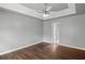 A bright bedroom features hardwood floors, and a white ceiling fan and overlooks an attached bathroom at 6332 Fairoaks Pl, Douglasville, GA 30135