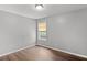 Bedroom features neutral paint, hardwood floors, and a window with blinds letting in natural light at 6332 Fairoaks Pl, Douglasville, GA 30135