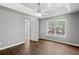 A bright bedroom features hardwood floors, a ceiling fan and a large window letting in lots of light at 6332 Fairoaks Pl, Douglasville, GA 30135
