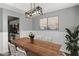 Elegant dining room with wood table, chandelier lighting, decorative wall paneling, and view of kitchen at 6332 Fairoaks Pl, Douglasville, GA 30135