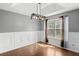 Well-lit dining room features elegant wall paneling, wood floors and a view to the home's backyard at 6332 Fairoaks Pl, Douglasville, GA 30135