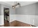 Bright dining room featuring a modern chandelier, elegant wall paneling and a view of the kitchen at 6332 Fairoaks Pl, Douglasville, GA 30135