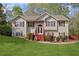 Charming two-story home with a well-manicured lawn and a welcoming front entrance with stone accents and red shutters at 6332 Fairoaks Pl, Douglasville, GA 30135