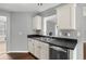 A charming kitchen features white cabinets, dark countertops, and stainless steel appliances at 6332 Fairoaks Pl, Douglasville, GA 30135