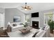Bright living room featuring a fireplace, ceiling fan, modern furniture, and natural light from the windows at 6332 Fairoaks Pl, Douglasville, GA 30135