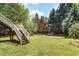 Expansive backyard with lush green grass, mature trees, and access to a raised deck with stairs at 1257 Arkwright Se Pl, Atlanta, GA 30317