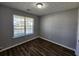 An empty bedroom with wood floors, neutral walls, and a window with blinds at 118 Dove Lndg, Social Circle, GA 30025