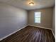 An empty bedroom with wood floors, neutral walls, and a window with blinds at 118 Dove Lndg, Social Circle, GA 30025